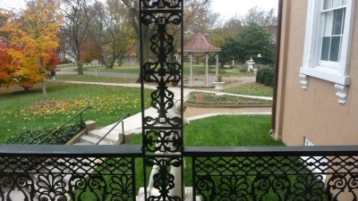 Window from the front with a balcony where you can see the grounds and the gazebo in front of Belmont Mansion.
