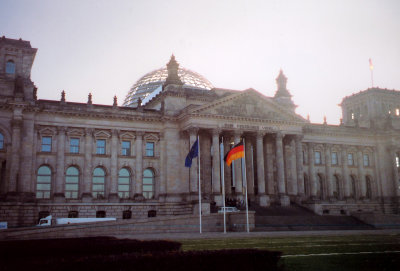 Frontal view of the Reichstag with flags flying.