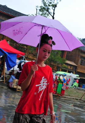 Miao girl warding of the rain