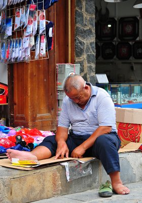 Xijiang Miao Village - sleeping vendor
