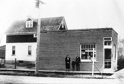Research amongst former Charleswood residents of the 1940 era concludes these two buildings were located on the corner of Elmhurst Rd and Roblin Blvd. The brick building in the foreground was a grocery store/Post Office and operated by Tommy Chester then later by the Bloomer family. Later it was named The Willows and served as a short order restaurant ie hamburgers, pizza, etc. 
The house behind the store was also owned by Tommy Chester who rented it to Bill McKennitt's mother and the family (Marnee, Bill & Sharon) lived there for a number of years.
If you're interested or ever lived in the area, send me an email and I'll provide some further history.