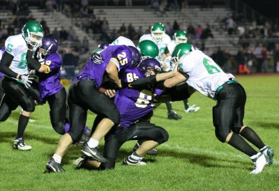 ....then driving his opponent into the running back who is also being tackled by Dan Gosney