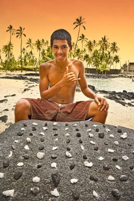 Boy playing konane (Hawaiian checker board game)