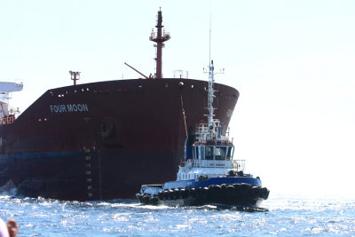 Tug boat pulling a cargo ship