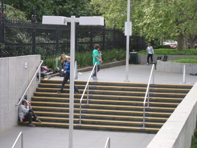 A picture of some local kids using a stairway as their own skateboard jump