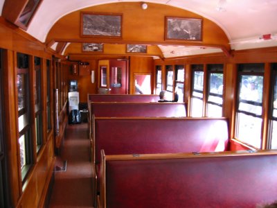 A view from inside the train. All of the seats are on the right side of the cabin