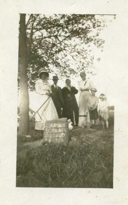 This interesting photo was sent to me .
Thank you so much for sending me this most interesting photo!
I wish I could figure out what the woman is holding in her hand.
I really like the head stone with its primitive form.