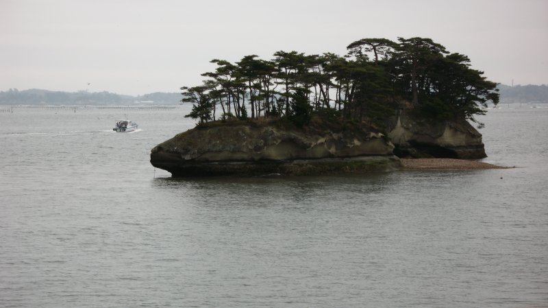 Island in the bay with passing boat