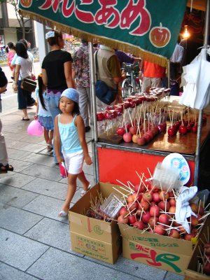 Pouting girl next to candied fruit stand