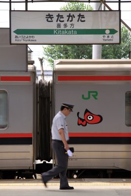 Conductor walking past an Aizu train