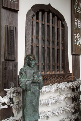 Temple window with statue and omikuji