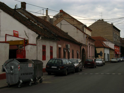 Curbside-parked cars and old houses, Zemun