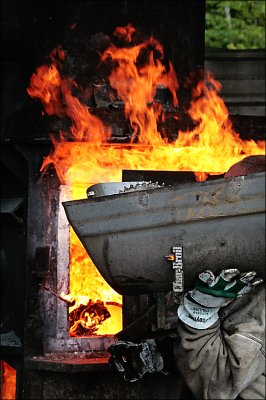 Wondo dumps parts into the furnace.