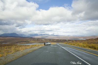 Now Paved Road with Lone Car on Road