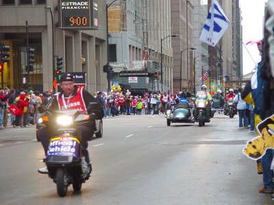 Elite runners, led by motorcycles