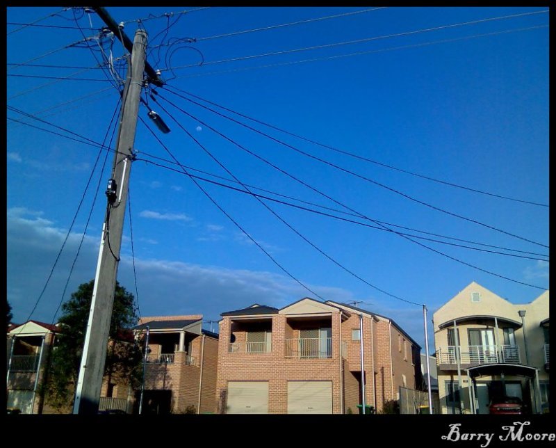Aug 25pm Moon trapped by a  web of power lines