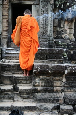 No he is not smoking a big joint, but burning some encent to Buddha - Angkor Wat - Cambodia