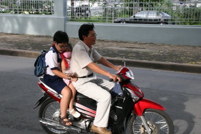 whole family on a motorbike and no helmets!