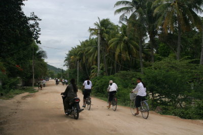 Schoolgirls cycle home in rural South Cambodia