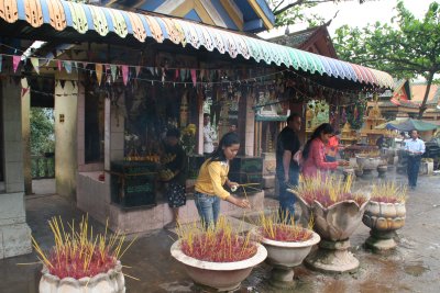 locals offering burning incense to the Buddha