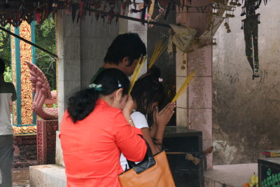 locals offering burning incense to the Buddha