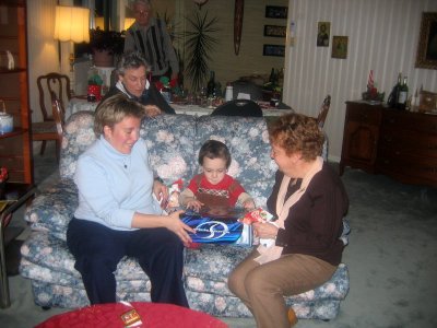 Philippe avec maman et grand-maman alors qu'Hélène observe le déballage de cadeau