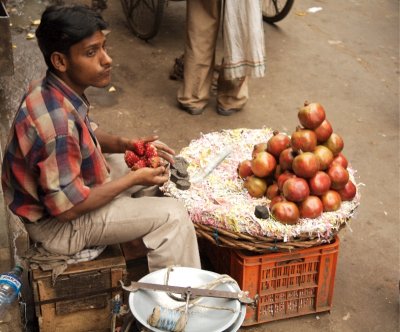 Young man prepares pomegranate, Spice Market, Old Delhi