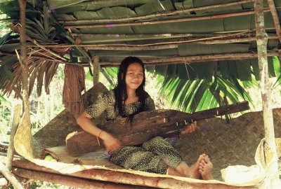 A Penan girl playing the Sape. We were lucky to come across this temporary settlement.