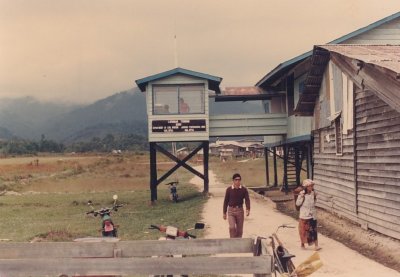 The village road passes below the Control Tower. In 1987 everybody walks. In 2005 on our 2nd visit, everybody rides a honda cup.