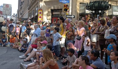 The crowd enjoys a street performer