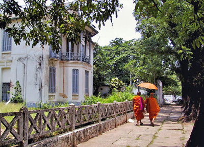 Monks walking past an empty villa