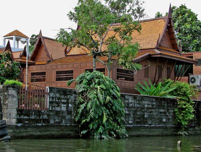 Teak house behind wall