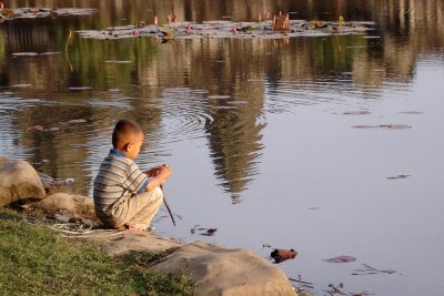 Boy by the pond with reflection