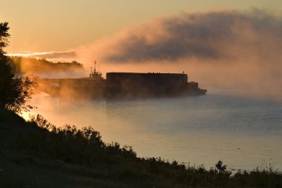 Barge and tug docked as dawn lifts fog