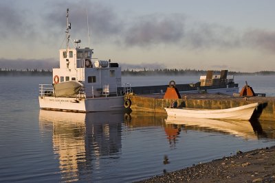 Barge Manitou II and canoe docked as fog lifts