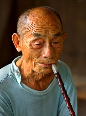 3681 Kam elder smoking a traditional bamboo pipe with ceramic bowl.