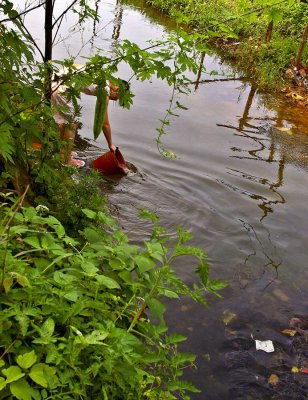 0501 Dumping garbage into the village stream.