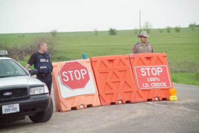 Texas Highway Patrol Officer and a Second Gentleman with full arm tatoos maning the Checkpoint to the Western Whitehouse