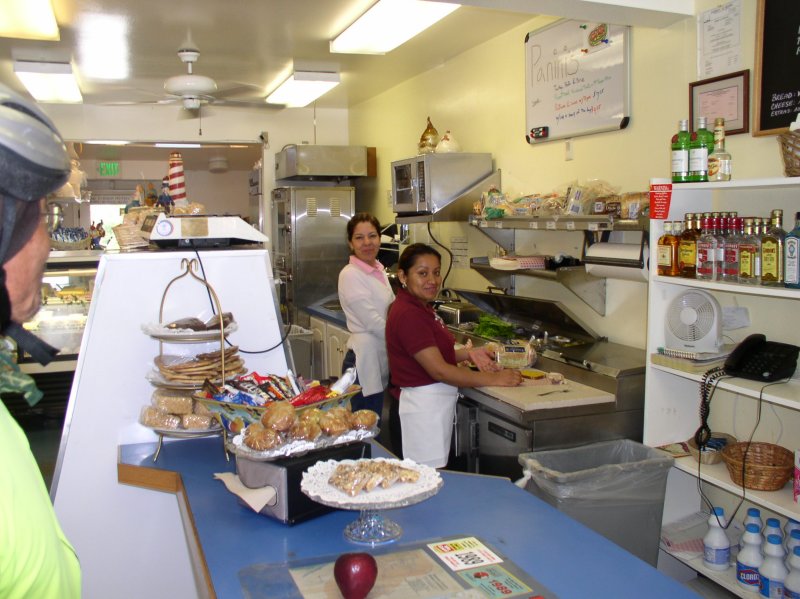 Friendly store owner in white.