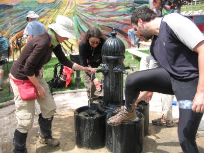Cleaning muddy boots at a water fountain near Viana