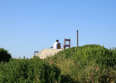 Solitary guitarist on bunkers above Baker Beach