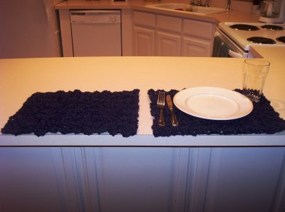 A picture showing 2 placemats I made, with one having a place setting on it.
