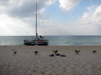We travel onto a beach and see a catamaran
