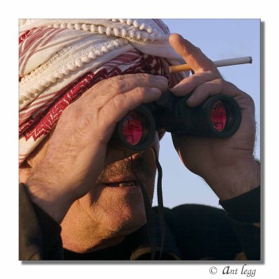Najim with binoculars and cigarette