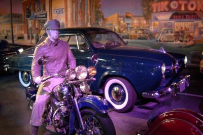 That's a 1950 Studebaker Champion Starlight Coupe behind the Harley.
