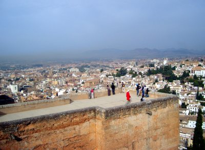 the castle tower of the alhambra over the town of granada