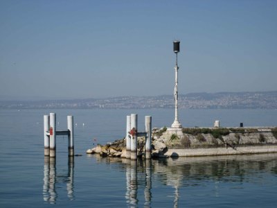 Un des feux du port d'Evian avec Lausanne en arrière-plan