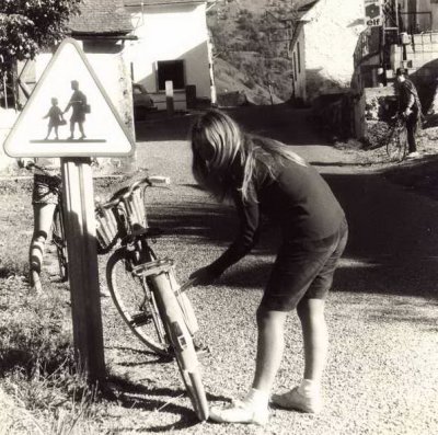 Marie gonfle sa bicyclette, sous l'oeil d'Edouard son frre.