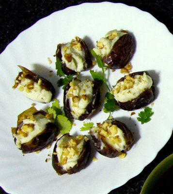 dates stuffed with cabrales cheese medley, topped with walnuts