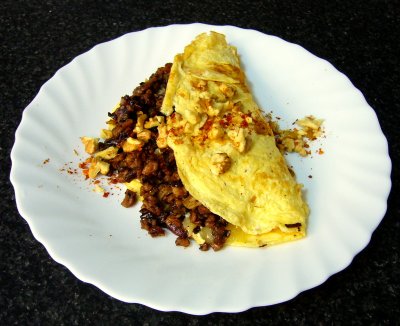 omelete with saueed mexican style soya protein, onions, peppers, chili, cumin, cacao & more, topped with walnuts